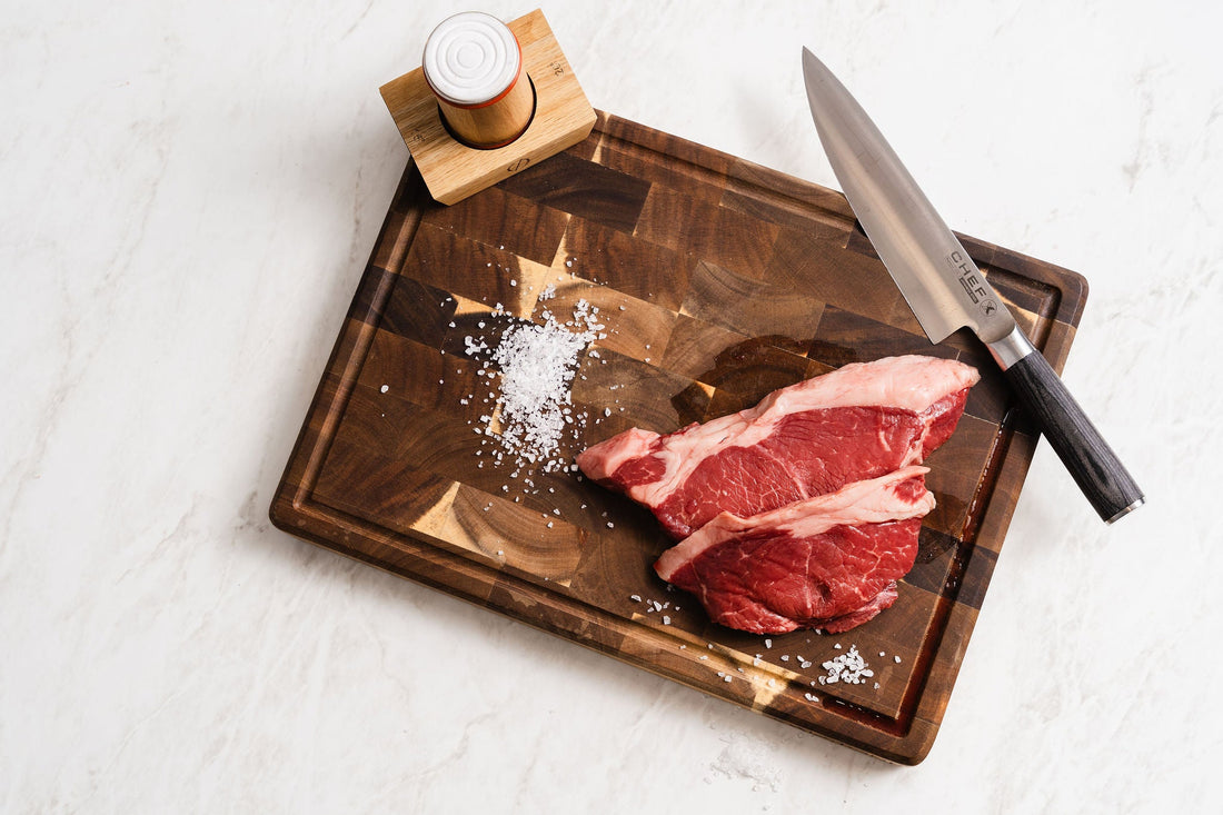 Knife and salt on a wooden chopping board on marble
