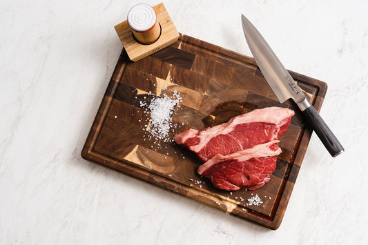 Knife and salt on a wooden chopping board on marble