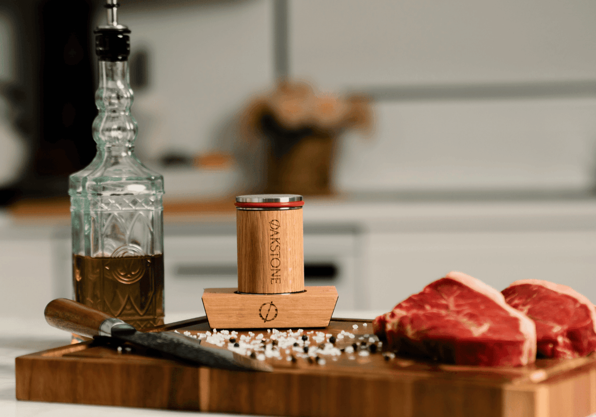 Oakstone roller on a chopping board with raw meat, a knife and oil