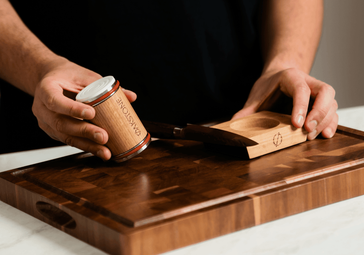 Hand holding the Oakstone oak roller and a knife on a chopping board