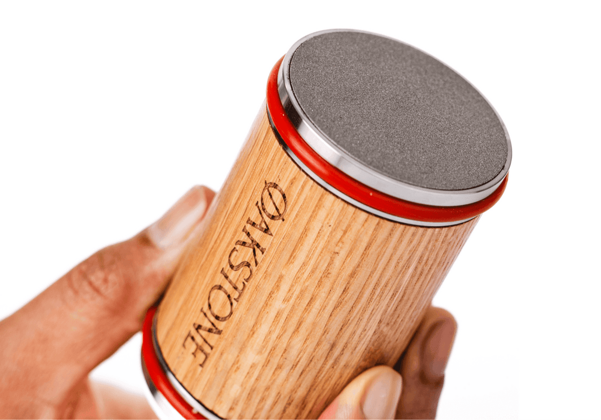 Hand holding the Oakstone oak roller with its red rim