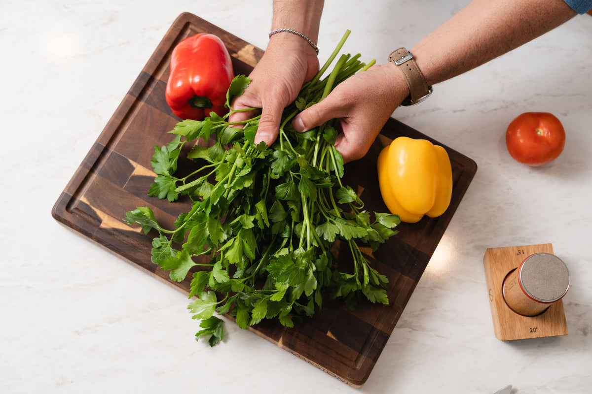 Herbs and vegetables on a wooden chopping board