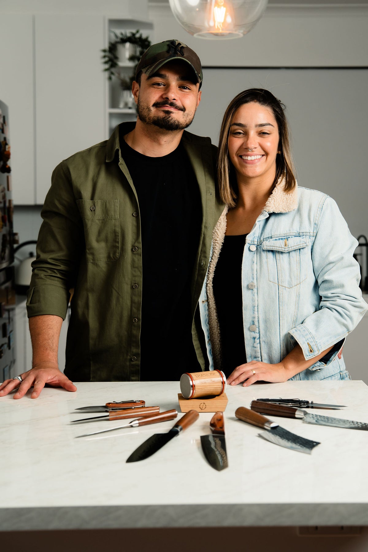 The Oakstone founders standing behind a table displaying knives
