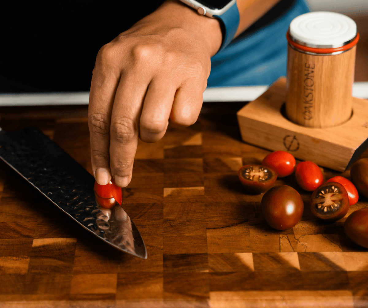 Slicing a tomato on a wooden board beside the Oakstone sharpener
